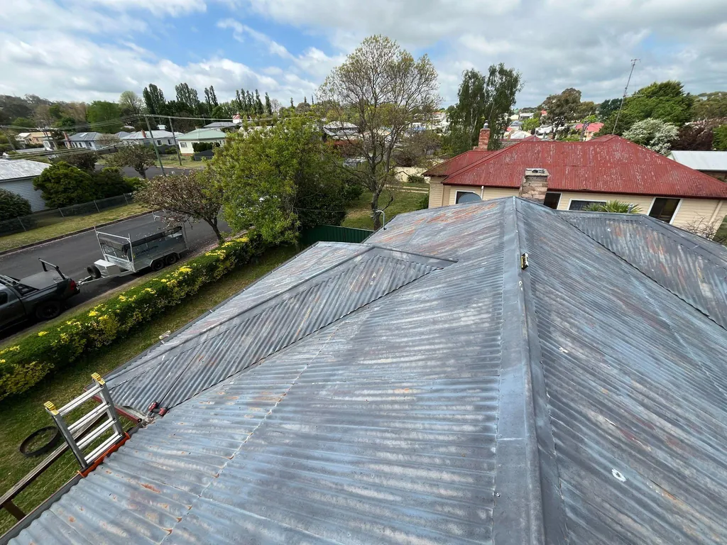 Before: weathered, corroded roof sheeting