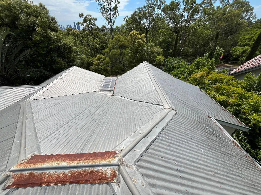 Before: corroded flashings on a hip roof