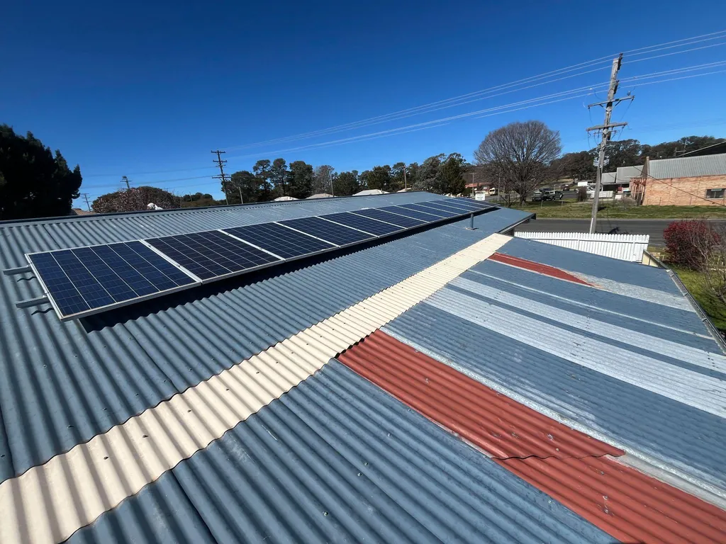 Before: patched, mismatched roof sheeting with solar panels