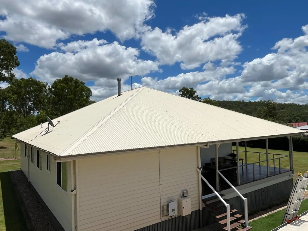 After: new cream metal roof on the same house